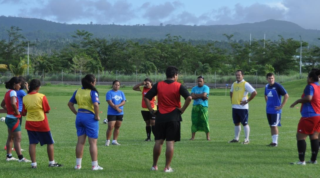 A group of volunteer sports coaches and local children prepare for a football match in Samoa. Projects Abroad volunteers coaching sport in Samoa help prepare children to participate in a football match.